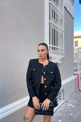 a lady in a black tweed crop coat and a pair of black shorts
